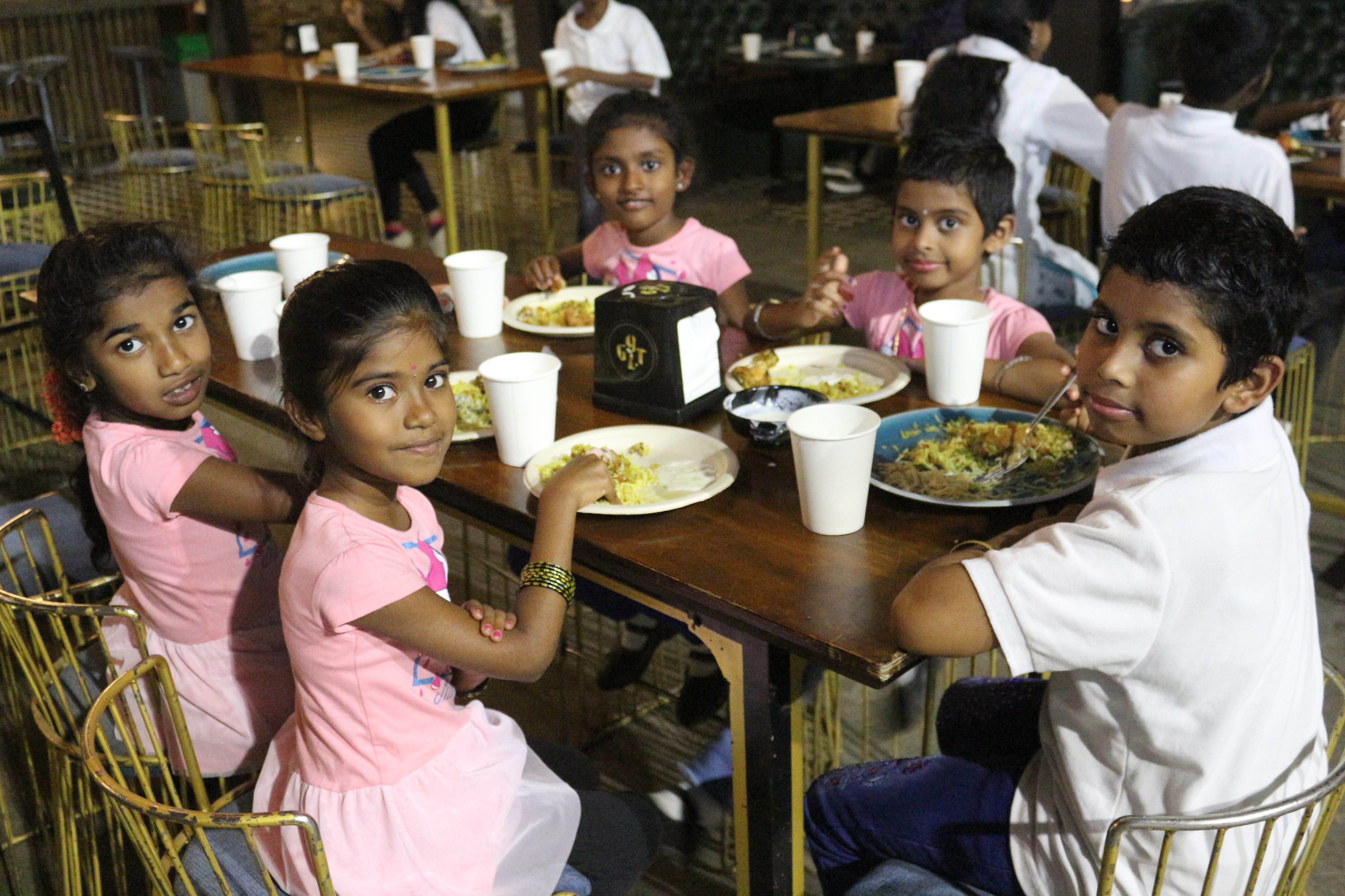 Volunteers sharing a meal with children